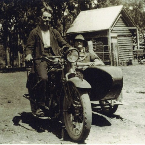 a vintage photo of a person riding on the back of a motorcycle