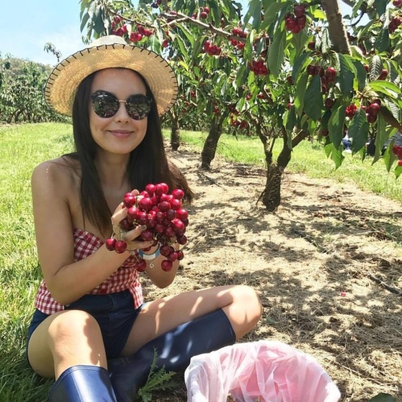a woman sitting on a bench posing for the camera